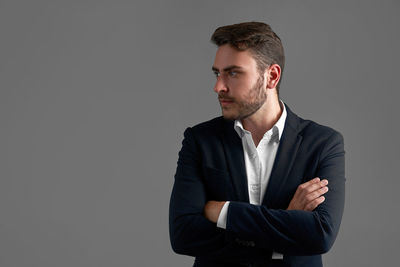 Young man looking away against black background