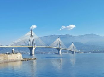 Low angle view of rio–antirrio bridge over sea against blue sky