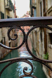 Close-up of metal railing against water