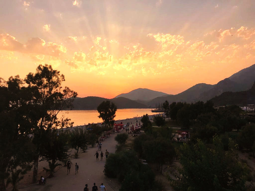 SCENIC VIEW OF SEA AND MOUNTAINS AGAINST SKY AT SUNSET