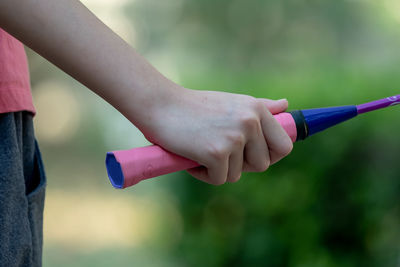 Cropped hand of woman holding badminton racket