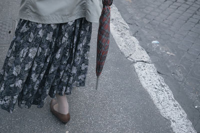 Low section of woman standing on street