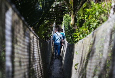 Rear view of woman standing on footbridge