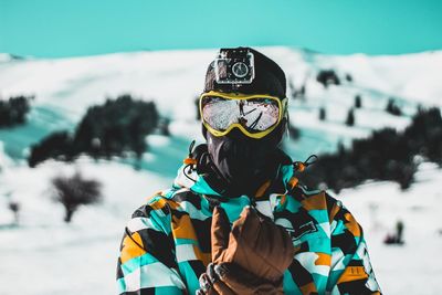 Man wearing warm clothing while standing against snowcapped mountains