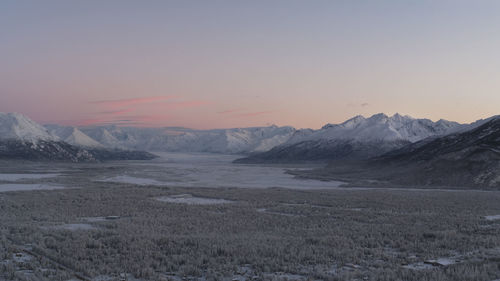 Scenic view of snowcapped mountains against sky during sunset