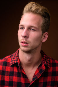 Close-up portrait of young man against black background