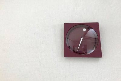 Close-up of eyeglasses on white wall