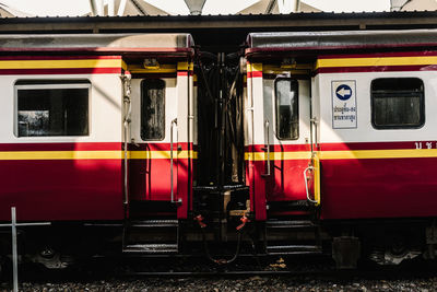 Side view of modern red and white wagons of train on railway station