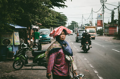 Woman riding bicycle on road in city