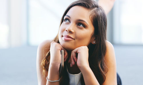 Smiling young woman day dreaming