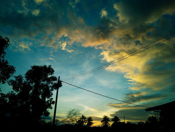 Low angle view of silhouette trees against sky