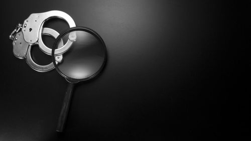 Close up of magnifying glass with handcuffs