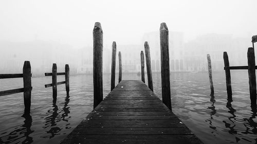 Wooden posts on pier against sky