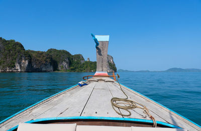 The bow of long tail boat riding on blue sea in sunny day of summer season