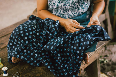 Midsection of woman knitting cloth