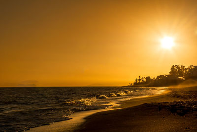 Scenic view of beach against sky during sunset