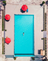 Aerial view of young woman relaxing on swimming pool