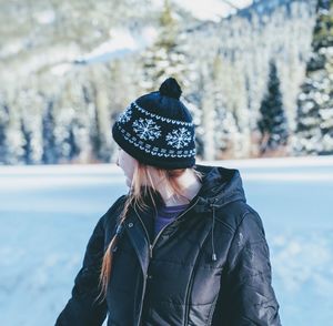 Midsection of woman wearing hat against trees during winter