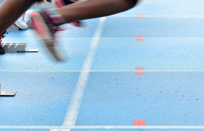 Low section of person running on field