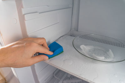 Defrosting .  a man wipes meltwater with a sponge. shallow depth of field. space for text.