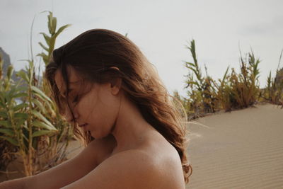 Side view of young woman on sand