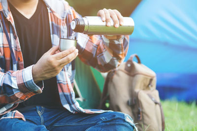 Midsection of man holding drink