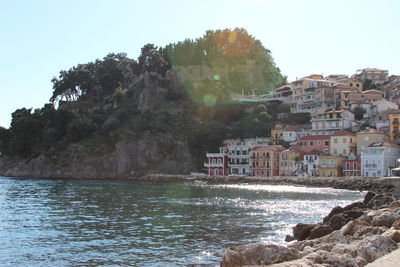 Scenic view of sea by buildings against clear sky