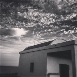 Low angle view of building against cloudy sky