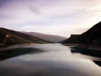 Scenic view of river amidst mountains against sky