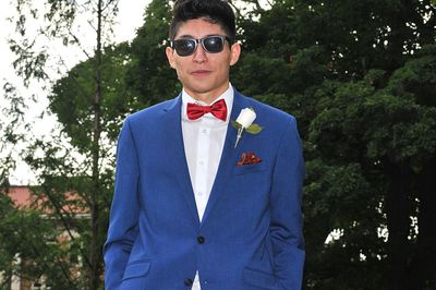 Portrait of young man wearing sunglasses standing against trees