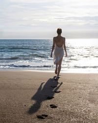 Full length of woman standing at beach