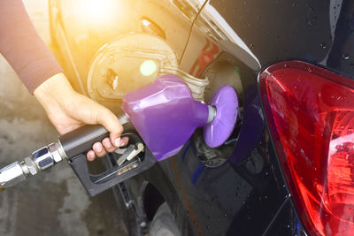 Cropped hand refueling car at gas station