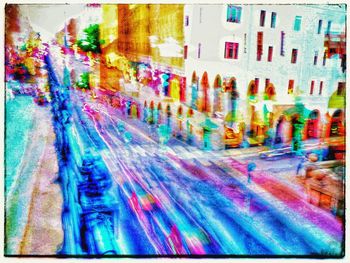 Blurred motion of multi colored umbrellas on city street