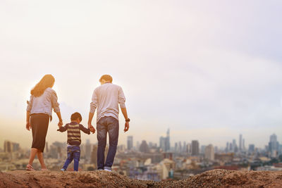 Rear view of father and son looking at cityscape