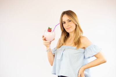 Young woman holding ice cream against white background