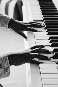 Cropped hand of child playing piano