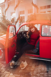 Portrait of a young woman in a warm knitted red sweater outside