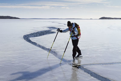 Person skating at frozen sea