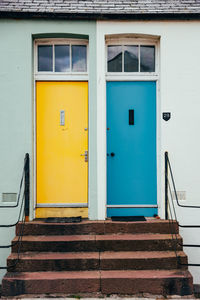 Blue and yellow colourful doors on seaside homes along the coast of scotland.