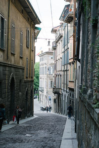 People walking on street amidst buildings in city