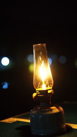 Close-up of illuminated lamp on table at night