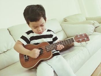 Boy playing guitar at home