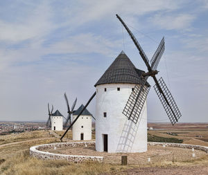 Traditional windmill on field against sky