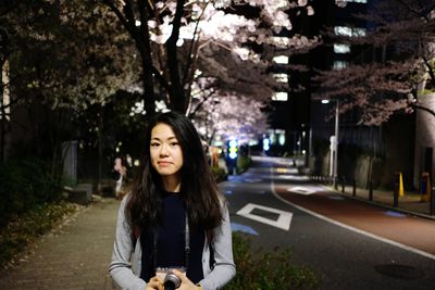 Portrait of young girl in city at night