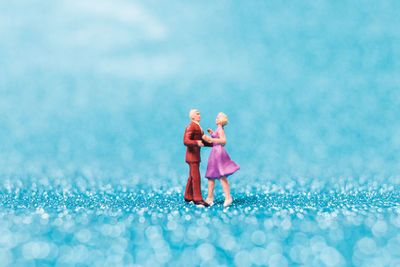 Close-up of couple figurines on blue floor