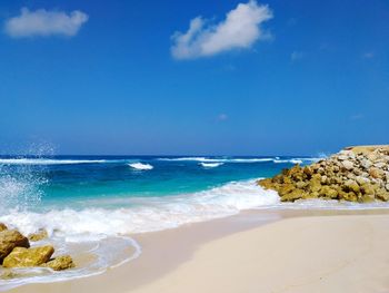 Scenic view of beach against blue sky