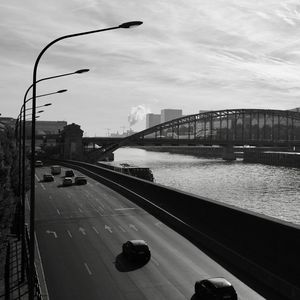Bridge over river against sky in city