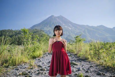 Portrait of woman standing on rocks against mountain