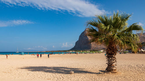 People at beach against sky