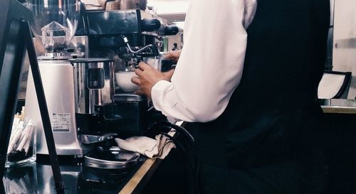 Midsection of man having coffee at cafe